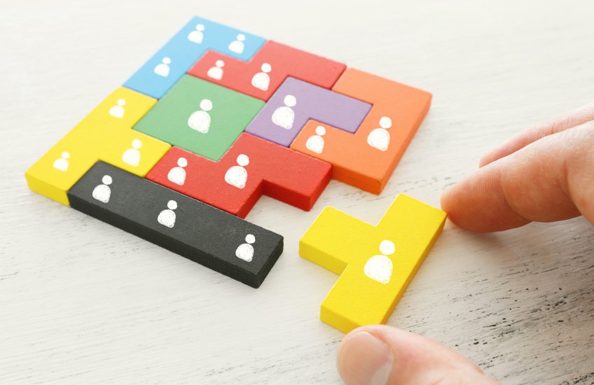 business concept image of tangram puzzle blocks with people icons over wooden table ,human resources and management concept